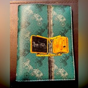 A Coach Passport Case with horse and carriage on cover.